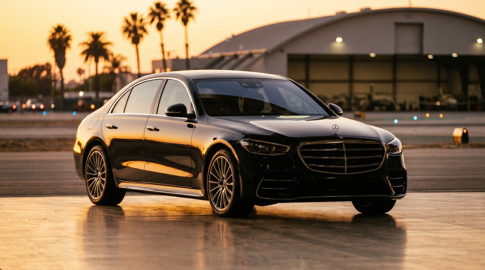 Black Mercedes-Benz S-Class waiting at LAX private terminal at golden hour